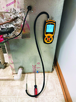 Evergreen Telemetry's around-the-door probe can also be used for checking under and around furnaces, as shown here.