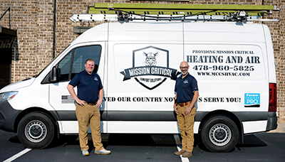 Photo of Ken Beasley and Clint Bremner standing in front of a Mission Critical Truck